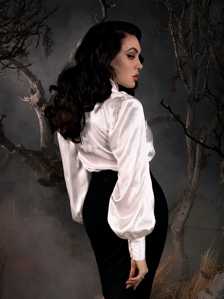 Micheline Pitt standing in a foggy, forest setting while wearing the Victorian Blouse in Ivory - a gothic style shirt with flowy sleeves. 