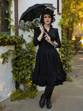 Model holds a parasol while wearing the Victorian Dress in Black to complete her gothic glam outfit.