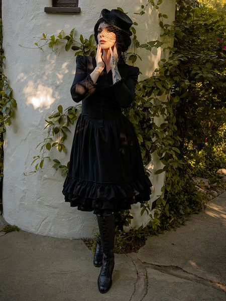 Gothic style dress paired with knee high black boots and black hat for goth style clothing brand La Femme en Noir.