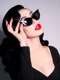 Micheline Pitt showing off her gothic retro outfit that includes the Vamp Batwing Sunglasses in Black.