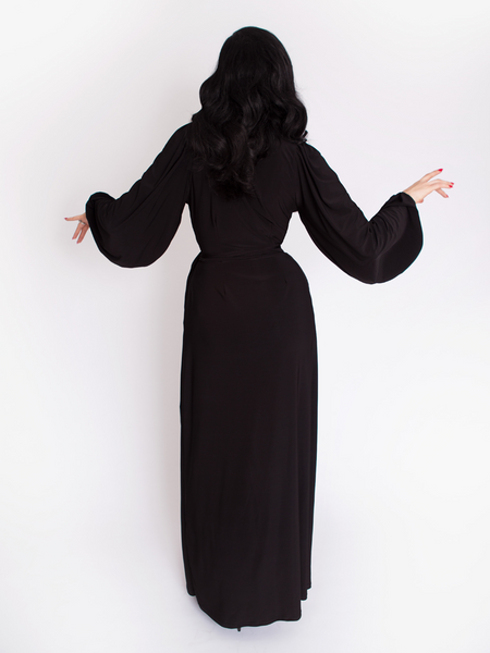 Back shot of Micheline Pitt wearing the gothic vintage clothing Black Widow Wrap Gown in Solid Black.