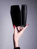 A product photo of hands with red painted nails holding the coffin case by La Femme En Noir.