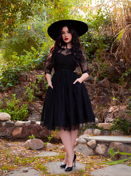 Positioned with her hands in her pockets and wearing a black sunhat, model Rachel Sedory looks ravishing in the Mourning Dress in Black Lace from La Femme en Noir.