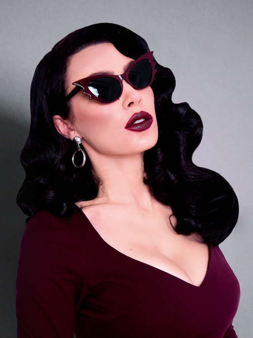 Micheline Pitt modeling the Vamp batwing sunglasses in oxblood.